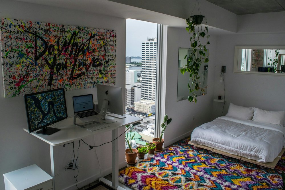 Small studio apartment with a made bed and desk