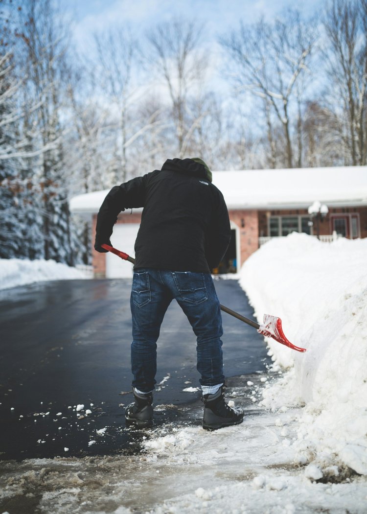 Person shovelling snow from a driveway