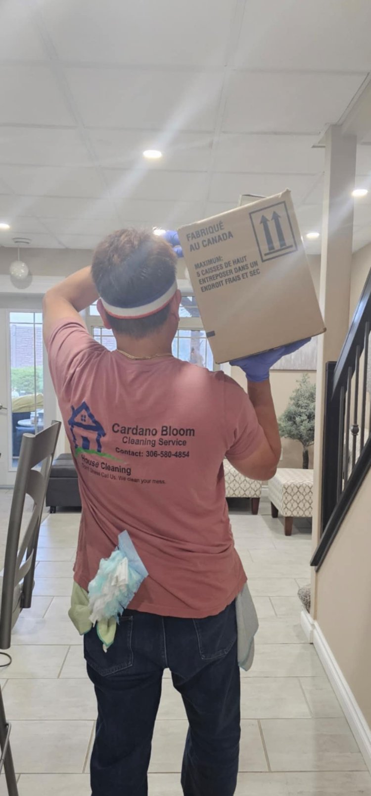 Cardano Bloom team member in a company shirt carrying a box